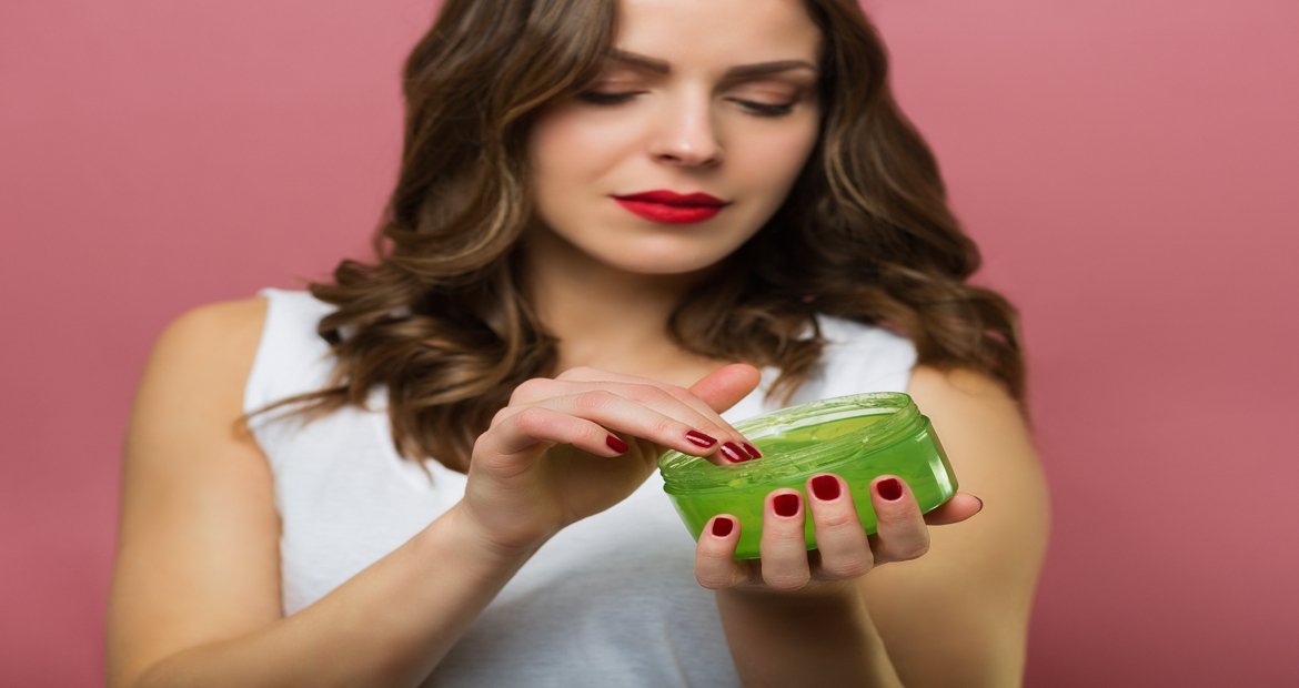 Mulher com frasco de gel de cabelo na mão